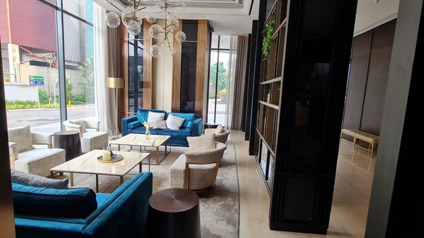 Ein modernes Interieur mit einem blauen Sofa, weißen Sessel und einem Couchtisch.