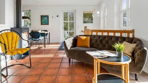 Una sala de estar acogedora con un sofá, una silla, una mesa y una chimenea.