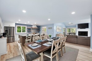 A modern kitchen with a dining area, a built-in oven, and a TV mounted on the wall. - Steps to the Beach on Seabrook! Family Favorite w/ Club Access (Seabrook Island)