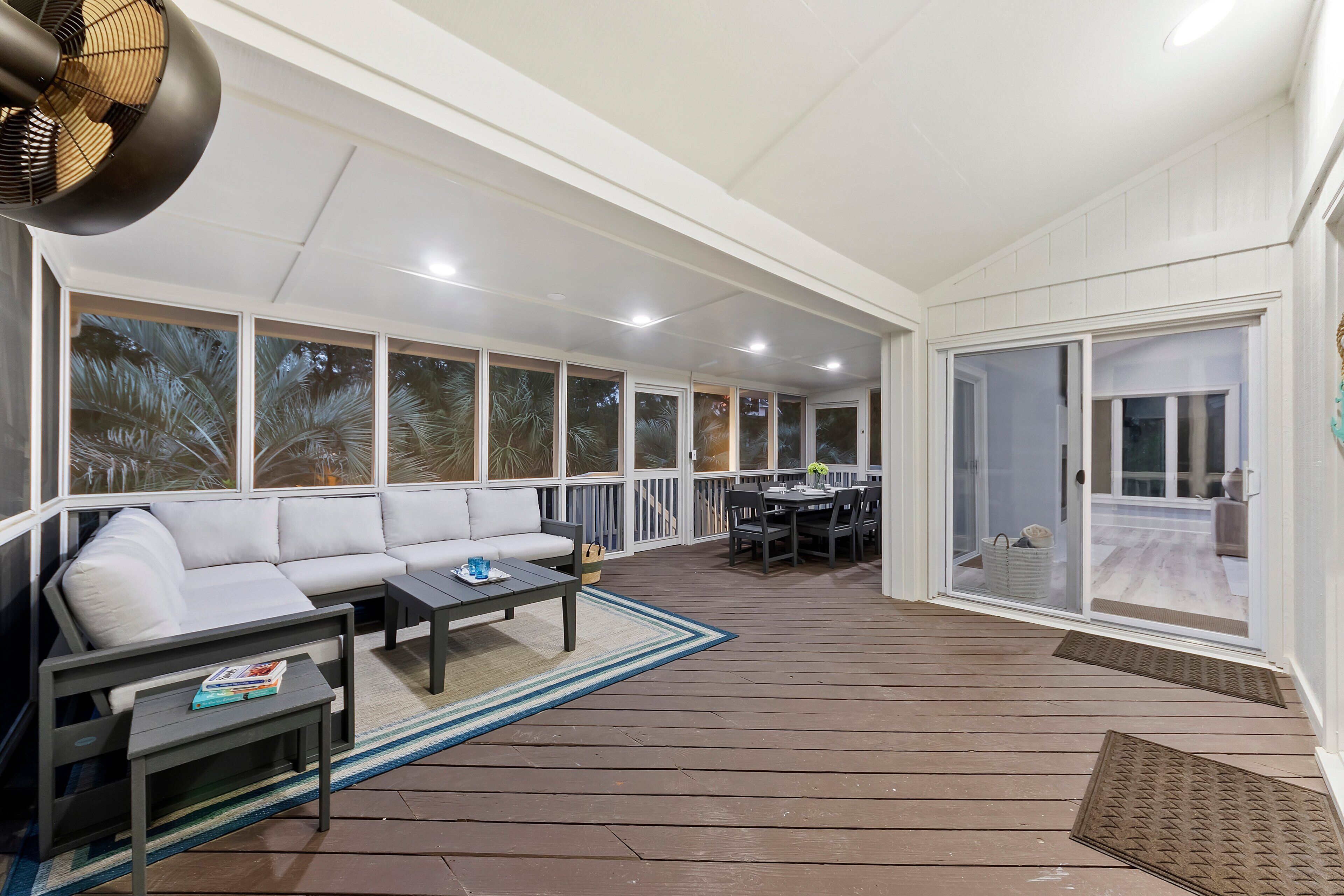 A covered patio area with a sofa, coffee table, and dining table.