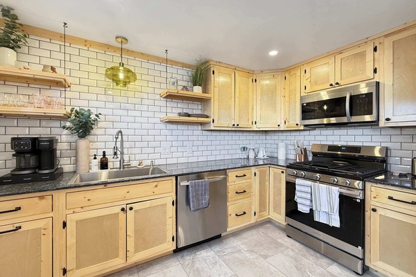 【Kitchen Detail】 Subway tile, butcher-block shelving, gas range — built for actual cooking