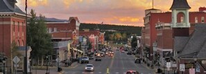 A street view of a town with buildings, cars, and a sunset in the background. - Poplar Street 1BR + Sauna — Walk to Main St, Pet-OK | Downtown Leadville (Leadville)