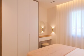 Une chambre à coucher moderne, avec un lit, une table de chevet, un miroir et un luminaire fixé au mur.