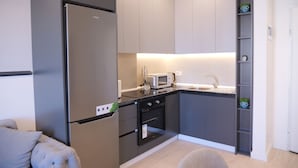 A modern kitchen with a built-in refrigerator, microwave, oven, and a sink. - Horizont Premium Apart-Hotel (Shkodër)