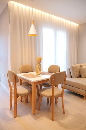 Un espace repas comprenant une table, des chaises, un vase et un canapé.