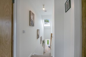A hallway with white walls, a wooden door, and a skylight. - Cove Lodge - Grampian Lettings (Aberdeen)
