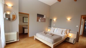 A bedroom with a bed, bedside tables, a mirror, and a wall-mounted artwork. - Your Provençal Escape among Olive Trees, with a Private Pool (CALLAS)