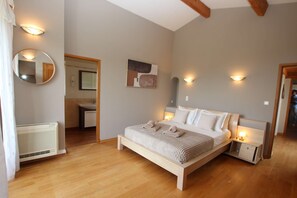 Ein Schlafzimmer mit einem Bett, Nachttischen, einem Spiegel und einem Wandbild.