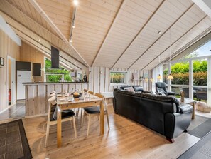 Ein modernes Interieur mit Essbereich, einer Couch und einer Küche.