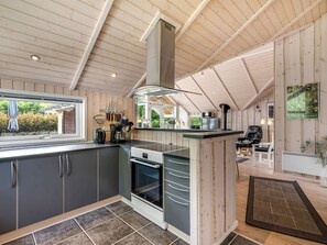 Eine moderne Küche mit Backofen, einem Fenster und Blick ins Freie.