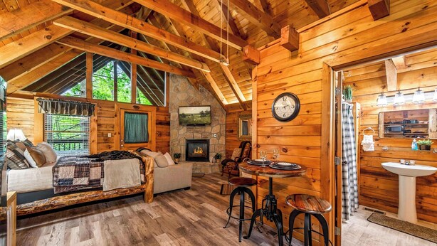 Ein gemütliches Blockhaus-Interieur mit Kamin, Essbereich und Badezimmer.