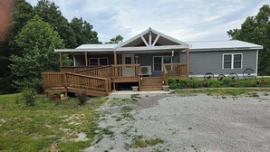 A two-story building with a wooden deck and a covered porch.
