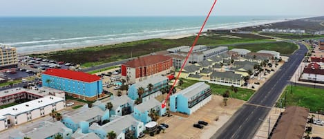 Un hôtel situé sur la côte, composé de plusieurs bâtiments, doté d’un parking et offrant une vue sur l’océan.