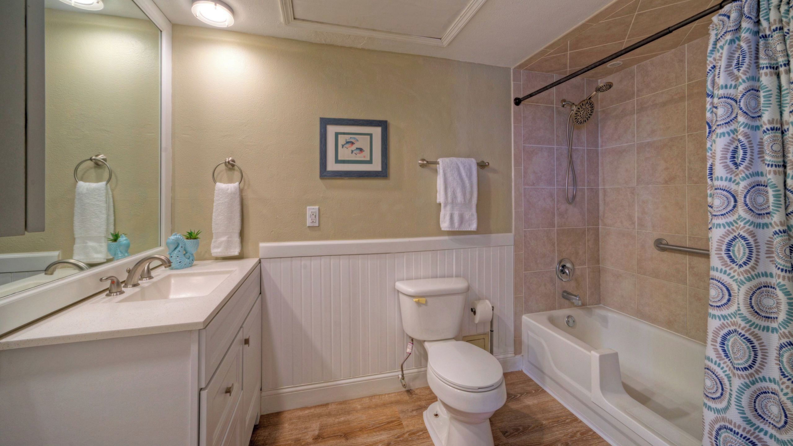 A bathroom with a toilet, sink, bathtub, and shower.