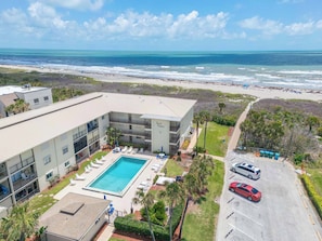 Ein Hotel mit Pool, Meerblick und Parkplatz.