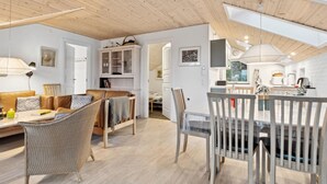 Um amplo loft com pé direito alto, área de jantar e cozinha.