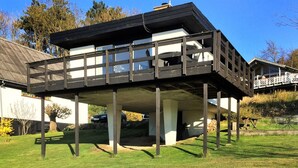 Een huis met twee verdiepingen, een balkon, een garage en een tuin.