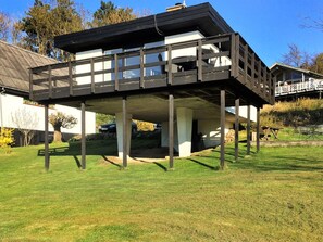 Ein zweistöckiges Haus mit Balkon, Garage und Garten.