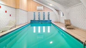 An indoor swimming pool with a wooden ceiling, white brick walls, and a blue pool cover. - "Stilla" - 19km from the sea by Interhome (Østervrå)