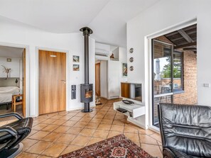 Ein modernes Interieur mit Kamin, einer Couch, einem Fernseher und einem gemusterten Teppich.