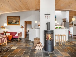 Ein gemütliches Wohnzimmer mit Kamin, Essbereich und Küche.