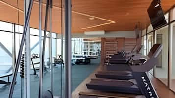 Uma academia com equipamentos de ginástica e esteiras.