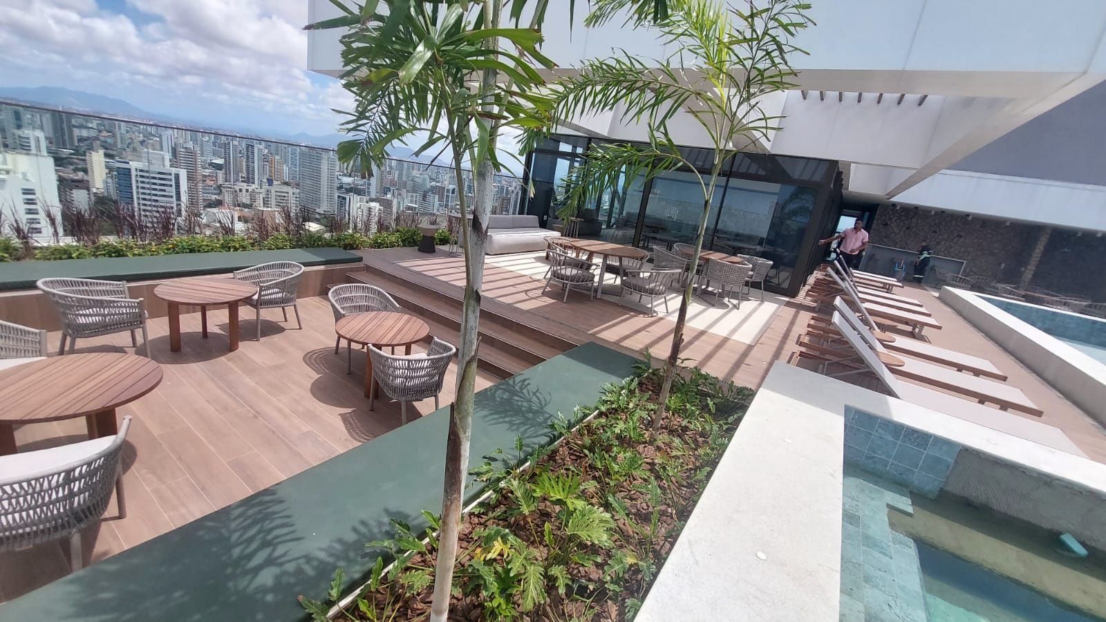 A rooftop terrace with outdoor seating, a pool, and a cityscape view.