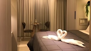 Quarto de hotel moderno com uma cama grande, uma escrivaninha e uma cadeira.
