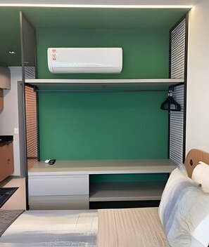 A bunk bed with a green wall, a white mattress, and a small desk area. - Beach Class Meireles by HostFácil (Fortaleza)