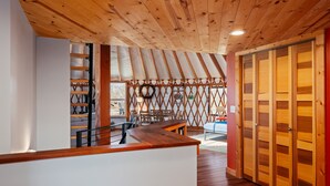Techo de madera, una escalera, un banco de madera y una puerta.