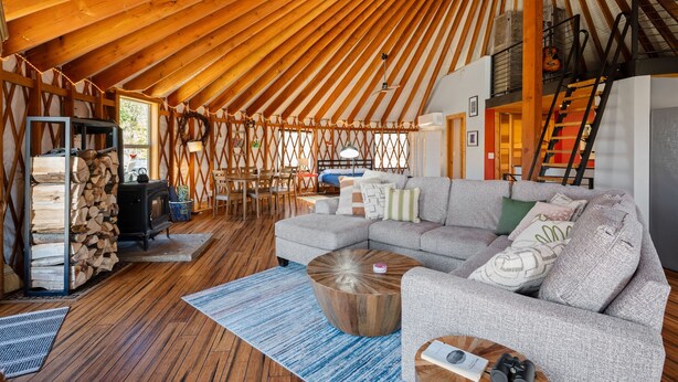 Una sala de estar acogedora con techo de madera, un sofá, una mesa de centro y una chimenea.