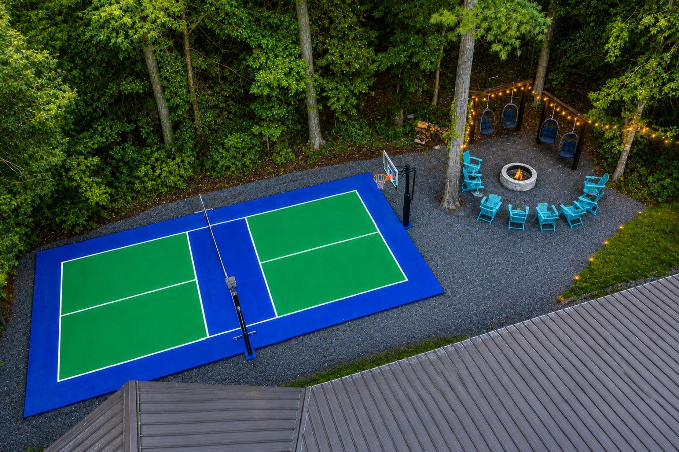 An outdoor tennis court with a fire pit and seating area.