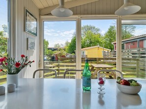 Ein Essbereich mit Tisch, Stühlen, einer Flasche S.Pellegrino Wasser und einer Obstschale.