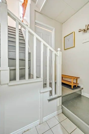 A staircase with white railings and a wooden bench at the bottom.