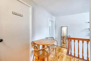 A private room with a wooden dining table and chairs, a mirror, and a wooden railing.