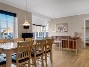 A spacious dining area with wooden chairs and a table, a sofa, a TV, and a painting on the wall. - "Verner" - 990m from the sea by Interhome (Skagen)