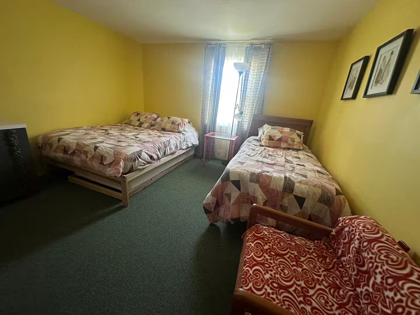 A room with two beds, a desk, a chair, and a TV.