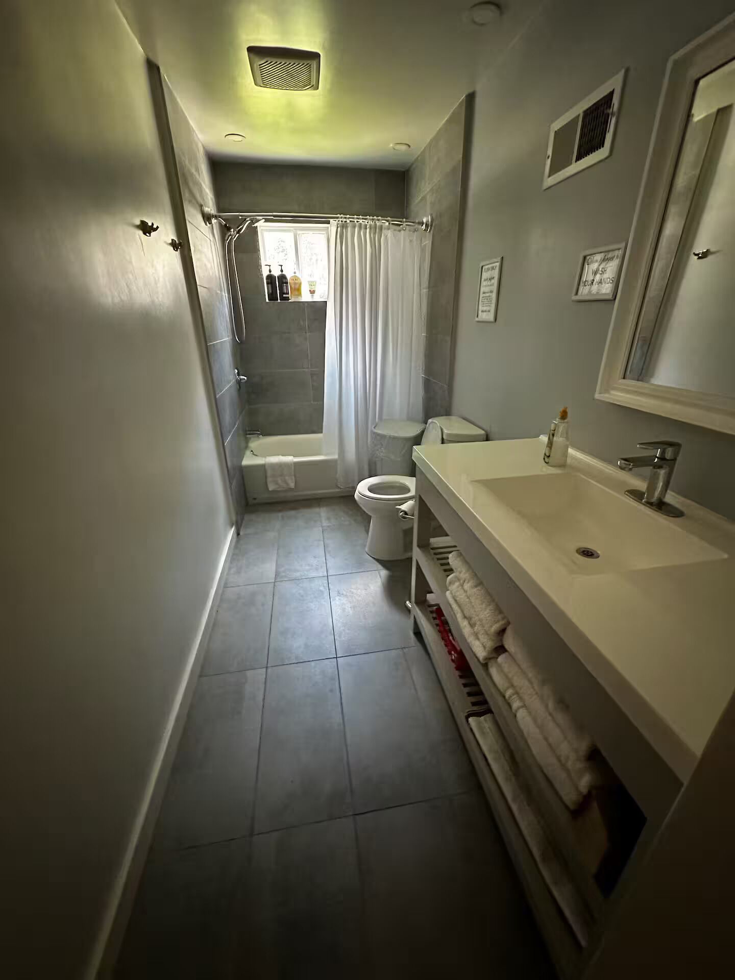 A modern bathroom with a shower, toilet, and sink.
