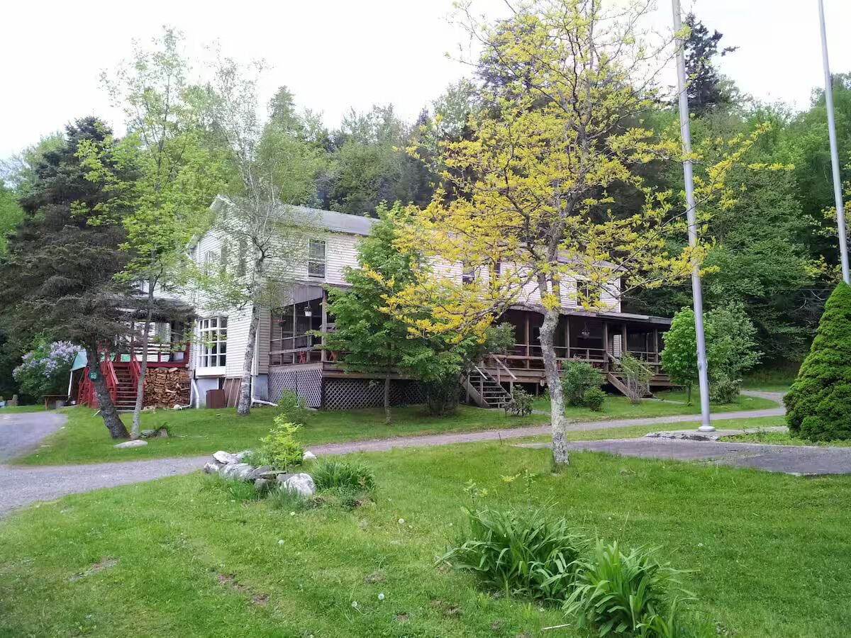 A two-story house with a front porch, a visible staircase, and a well-maintained lawn.
