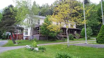 A two-story house with a front porch, a visible staircase, and a well-maintained lawn.