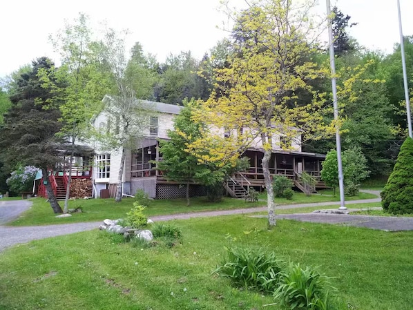 A two-story house with a front porch, a visible staircase, and a well-maintained lawn.