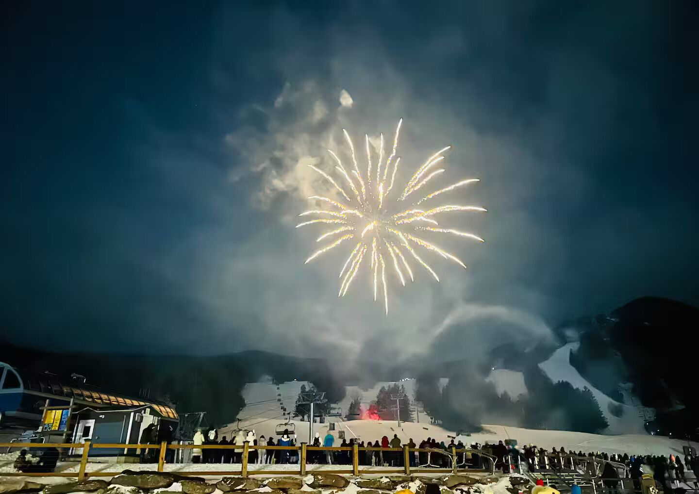 Paesaggio innevato con una seggiovia e un gruppo di persone.
