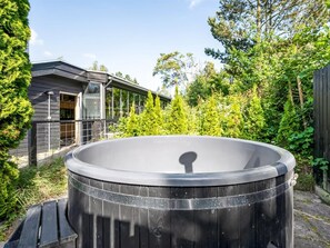 Ein Whirlpool in einem Garten, im Hintergrund ein Haus.