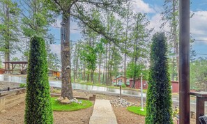 A pathway leading to a house surrounded by trees and a wooden fence. - Dad's Retreat | Walk to Midtown | Hot Tub | Fenced Yard | (Ruidoso)