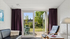 Ein modernes Zimmer mit einer Couch, zwei Sesseln, einem Tisch und einer Lampe.