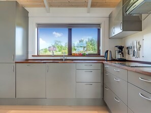 Eine moderne Küche mit Fenster, Einbauküche und Kaffeemaschine.