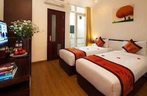 A hotel room with two beds, a television, a desk with a vase of flowers, and a painting on the wall. - Hanoi Serenity Hotel 2 (Hanoi)