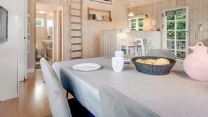 Een houten interieur met een eetgedeelte, een keuken en een badkamer.