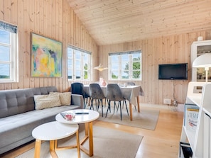 Une pièce confortable avec un canapé, une table à manger, des chaises et un téléviseur.