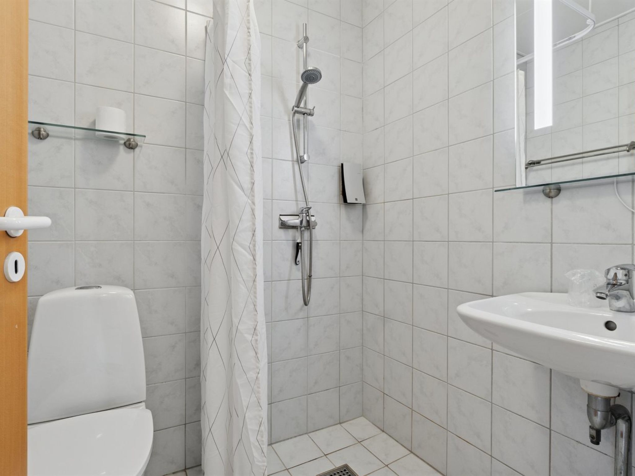 Ein Badezimmer mit Dusche, Toilette und Waschbecken.